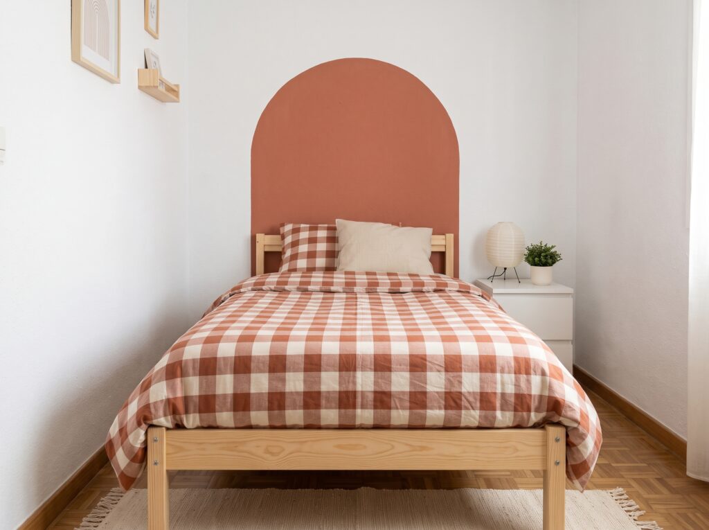 Dormitorio juvenil con cabecero pintado en forma de arco color terracota sobre pared blanca