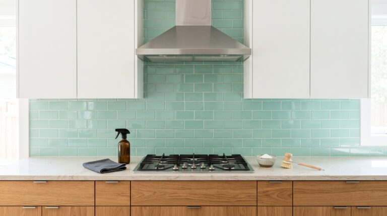 Cocina reluciente con campana de acero inoxidable limpia y utensilios de limpieza naturales sobre la encimera