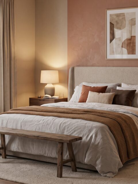 Dormitorio matrimonial acogedor con cabecero tapizado, ropa de cama de lino en capas y lámparas encendidas al anochecer